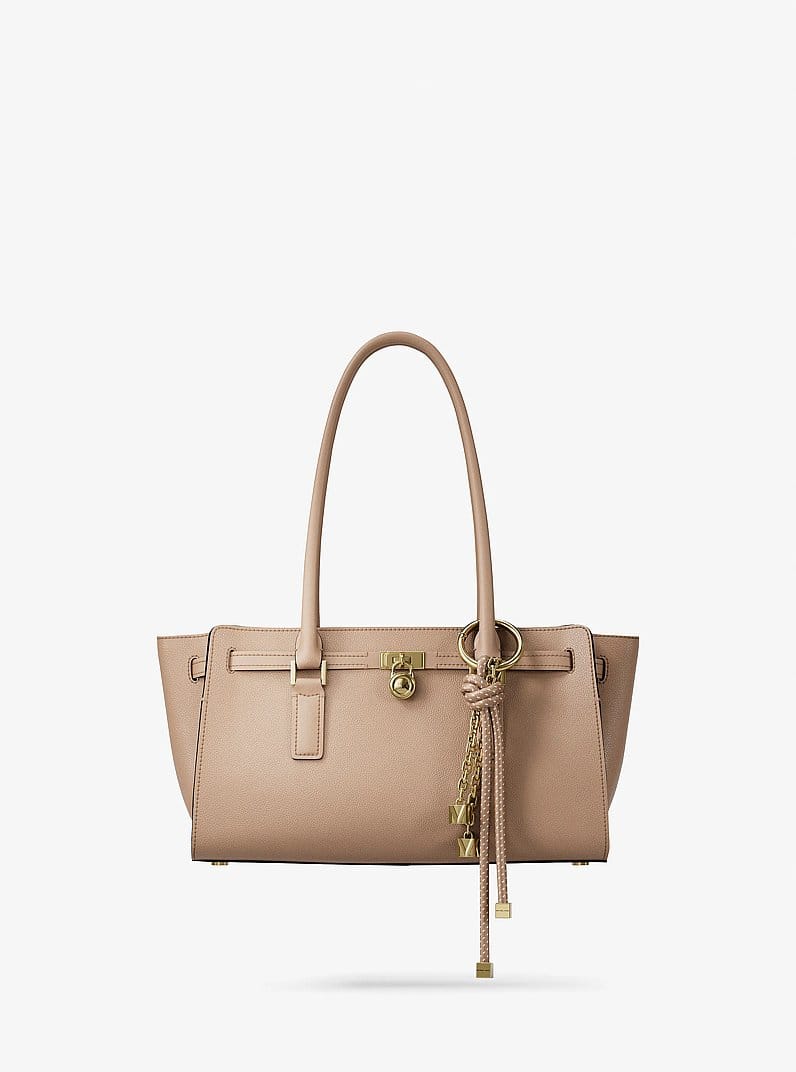 Beige tote bag with gold hardware and tassel charm